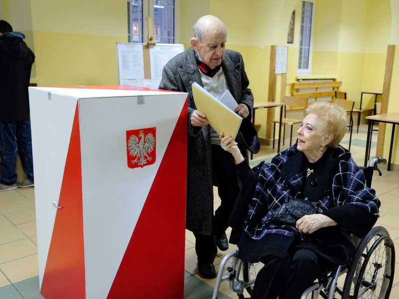 Kobieta na wózku z mężem przed urną | W maju 2015 r. będziemy wybierać Prezydenta RP, a jesienią 2015 r. – parlament /Fot. Piotr Stanisławski