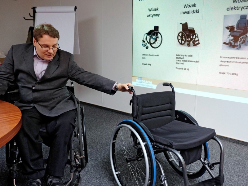 Trener Integracji podczas szkolenia pokazuje rodzaje wózków inwalidzkich