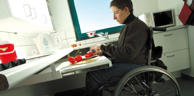 Osoba a wózku inwalidzkim w specjalnie przystosowanej kuchni/ sxc.hu