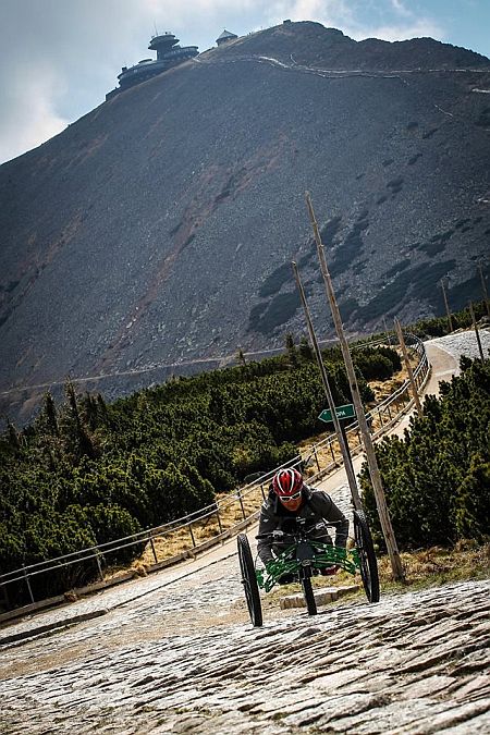 Mężczyzna na handbike'u na kamienistym szlaku górskim