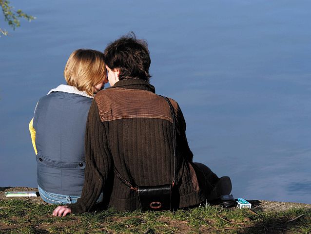 Kobieta i mężczyzna przytuleni na brzegu jeziora
