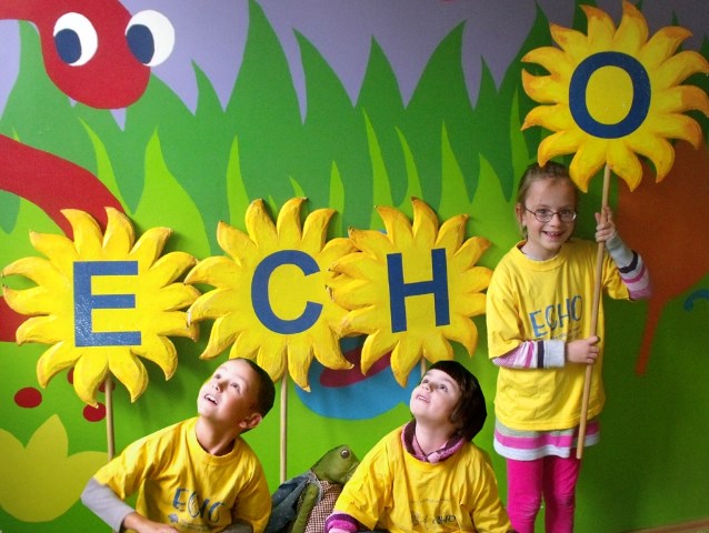 dzieci trzymają literki tworzące napis echo z narysowanych słoneczników