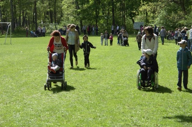 dzieci na wózkach z dorosłymi na trawie