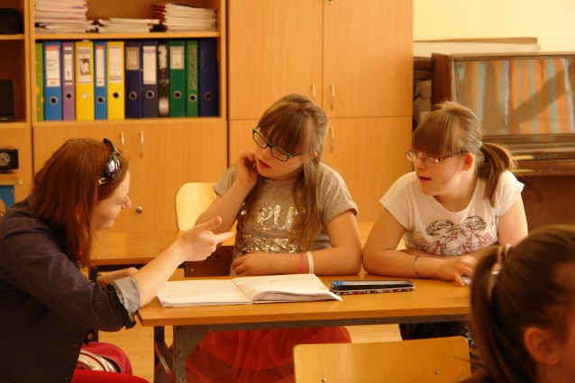 asystentka tłumaczy dwóm dziewczynkom lekcje