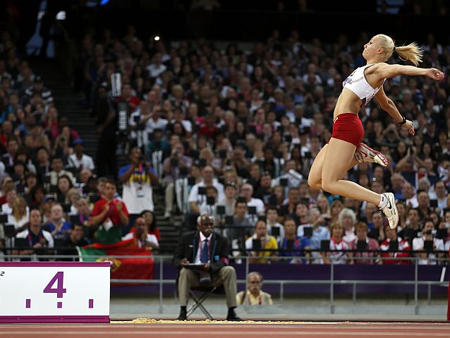 Karolina Kucharczyk podczas skoku w dal, w tle pełne trybuny