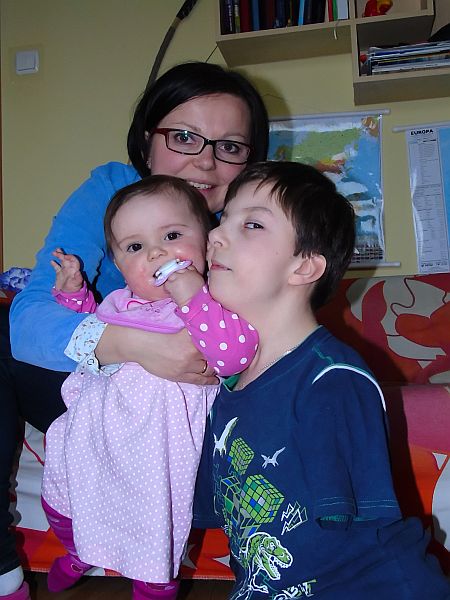 Mama trzyma 7-miesięczną Julkę, przytula się do nich Miłosz