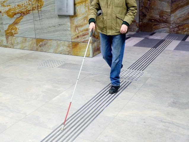 niewidomy mężczyzna idzie ścieżką w metrze