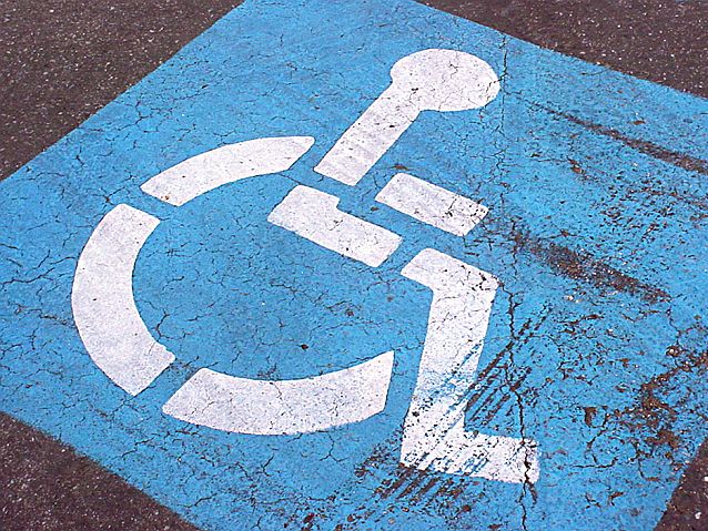 Niebieski symbol osoby na wózku namalowany na jezdni