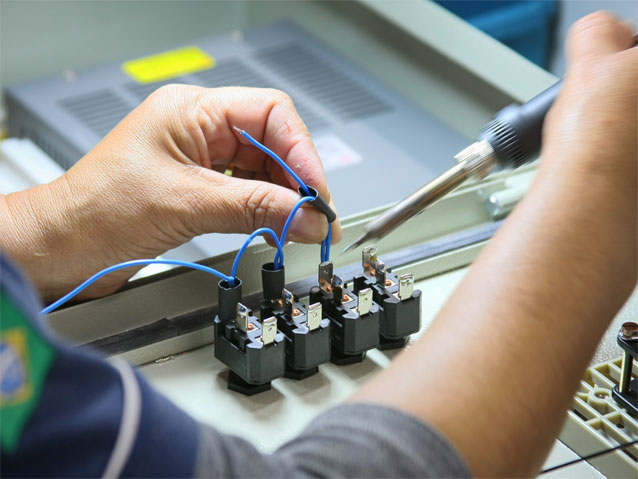 Pracownik techniczny montuje przewody w kondensatorze /www.sxc.hu