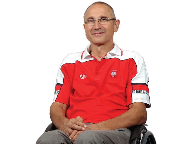 Mirosław Piesak siedzi na wózku w sportowej koszulce z białym orłem