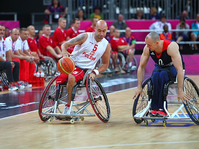 Dwóch zawodników koszykówki na wózkach. Polak przy piłce