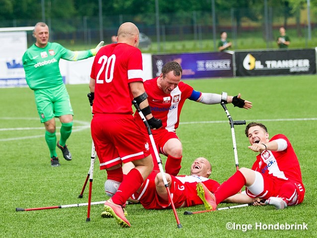 kilku sportowców z amp futbolu leży na trawie śmiejąc się