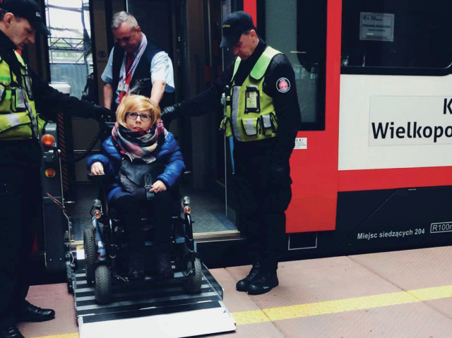 kobieta na wózku elektrycznym wychodzi z pociągu