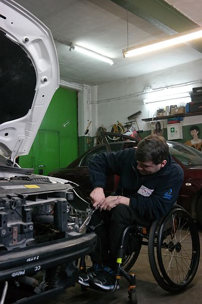 Kamil Więckiewicz na wózku naprawia samochód