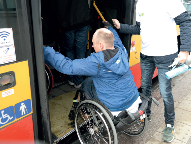 mężczyzna na wózku wjeżdża do autobusu miejskiego