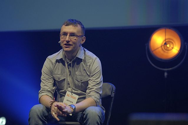Jacek Noch siedzi na krzesełku na scenie podczas Wielkiej Gali Integracji. 