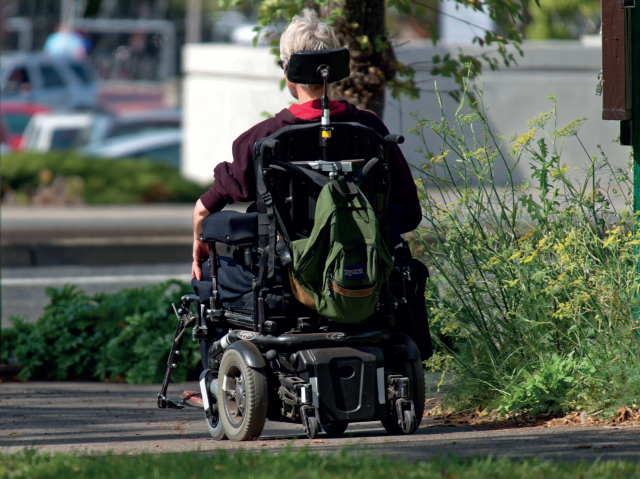 mężczyzna przemieszcza się po miejskim parku na wózku elektrycznym