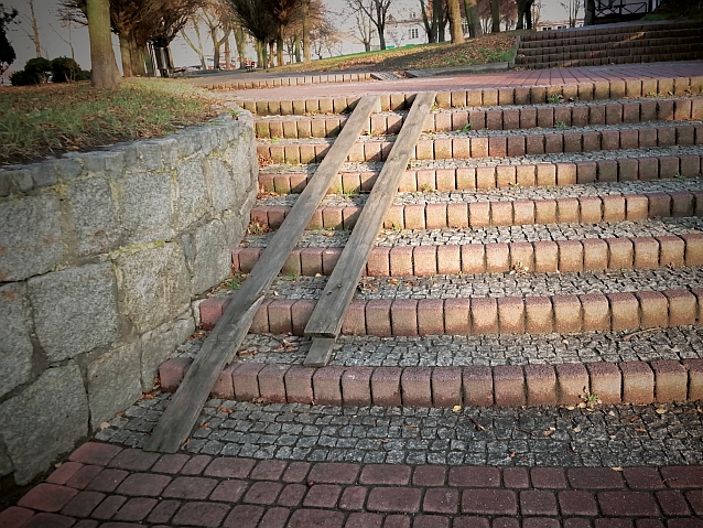 Murowane schodki, na których położone są deski, mające być podjazdem