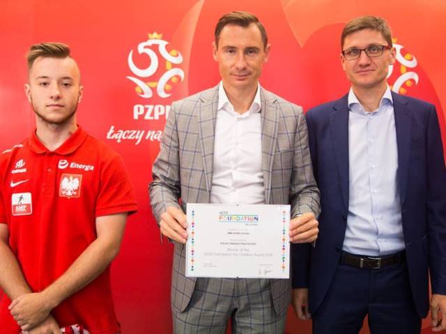 od lewej: ampfutbolista, Sekretarz Generalny PZPN Maciej Sawicki trzyma nagrodę i prezes stowarzyszenia Amp Futbol Polska Mateusz Widłak.