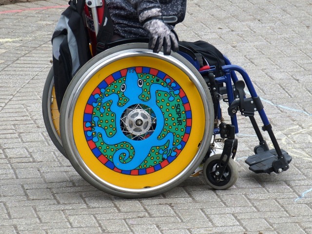 kolorowe koło od wózka, na którym siedzi mężczyzna