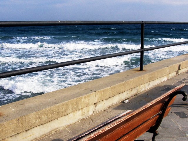 ławka jakby na tarasie widokowym, z którego widać morze