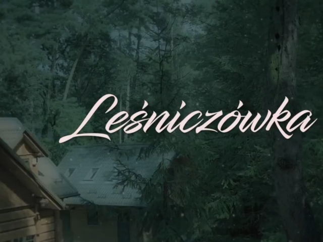 napis Leśniczówka na tle drzew i leśniczówki