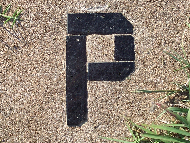 Ułożona z czarnej mozaiki w betonie litera P