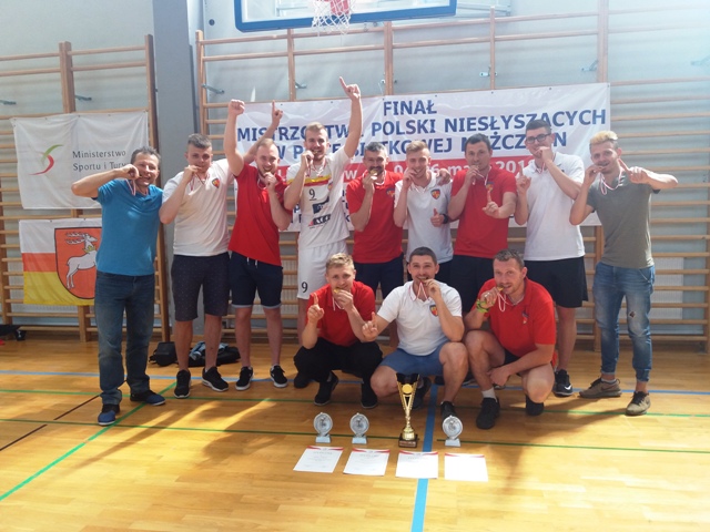 zdjęcie grupowe zawodnikow z MKSN Mazowsze, przygryzających swoje złote medale