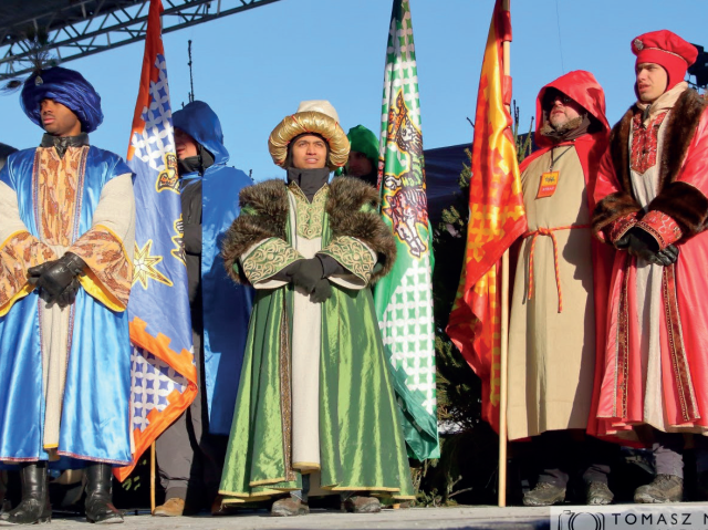 Trzech mężczyzn przebranych za trzech króli stoją na scenie podczas Orszaku Trzech Króli