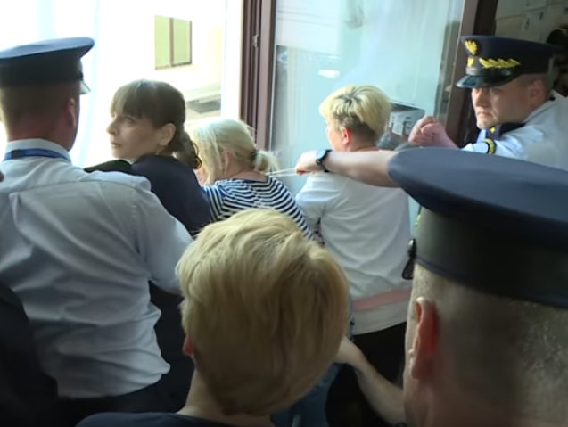Protestujące trzy matki wywieszają transparent przez okno w Sejmie, interwencja straży marszałkowskiej