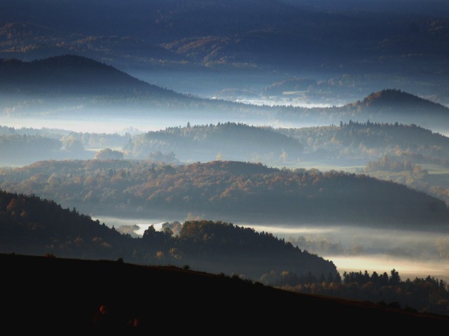 zalesione pasma górskie przetykane mgłą