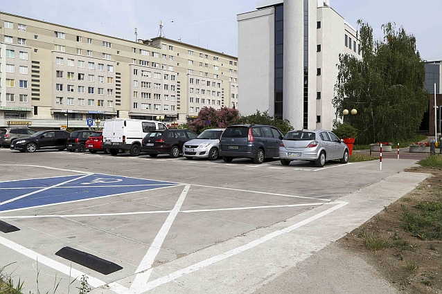 Pusta niebieska tzw. koperta, obok dwa inne puste miejsca parkingowe, w tle zaparkowane samochody