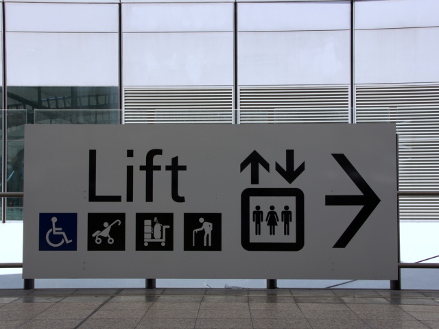 tablica informacyjna z napisem lift i logami osoby na wózku wózka dziecięcego, bagażowego i osoby z laską