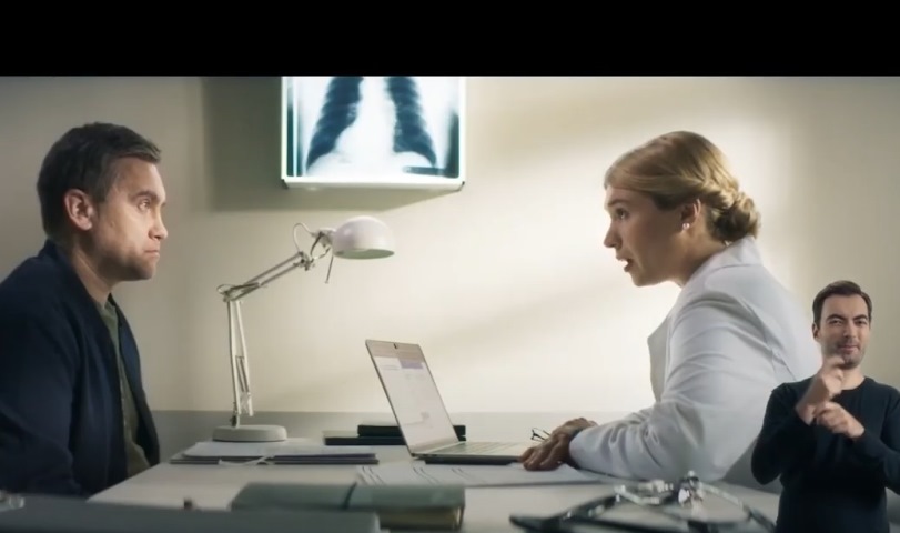 mężczyzna siedzi naprzeciw lekarki na dole tłumacz języka migowego