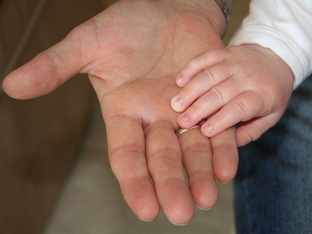Dłoń dziecka dotyka dłoni dorosłego mężczyzny