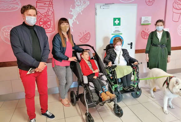 trzy osoby pełnosprawne i dwie osoby z niepełnosprawnością stoją przy wejściu do Komfortki w centrum Arena w Gliwicach