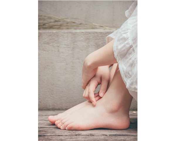kobiece stopy na nogi założone ręce kobiety siedzącej w kucki