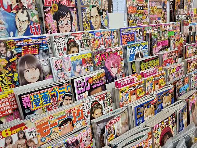 Kilkadziesiąt japońskich gazet na półkach w sklepie