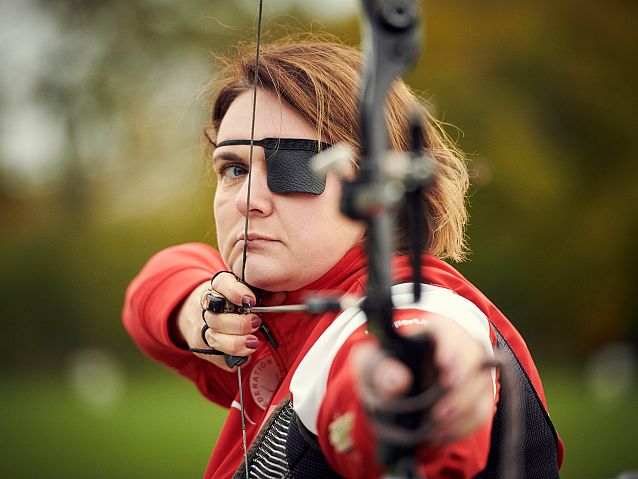 Zawodniczka trzyma uniesiony łuk z napiętą cięciwą