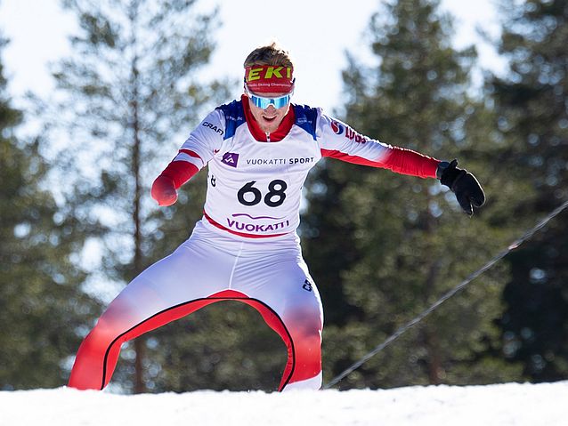 Wojciech Skupień biegnie na nartach w śniegu, nie używając kijków