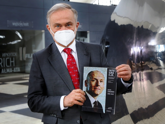 Prezydent Gdyni Wojciech Szczurek trzyma w dłoniach okładkę magazynu Integracja, na której jest Piotr Pawłowski