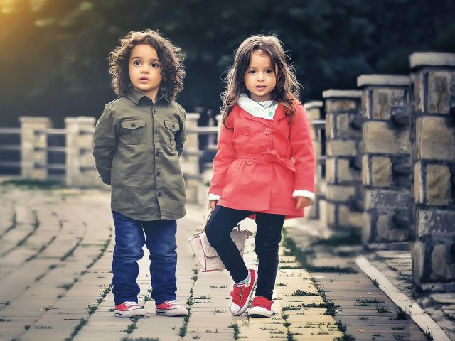 Na zdjęciu widnieje chłopczyk i dziewczynka stojący obok siebie