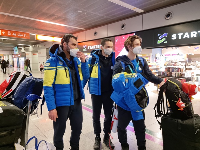 trzech młodych mężczyzn - paraolimpijczyków, ubranych w te same kurtki reprezentacji Ukrainy. Są na hali przylotów, obok nich stoją bagaże