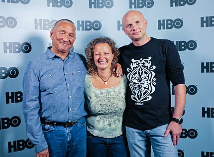 Na tle ścianki z napisem HBO stoją obejmujac się: Janusz Solarz, Joanna Hereta i Artur Dąbrowski
