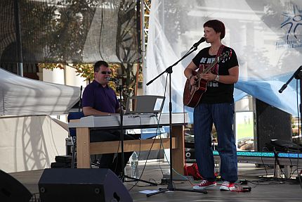 Na scenie śpiewa siedząc za pianinem Paweł Ejzenberg, obok niego stoi i gra na gitarze młoda dziewczyna