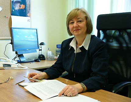 Teresa Hernik siedzi za biurkiem przy komputerze.