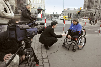 zdjęcie: kadr z reportażu - dziennikarz przeprowadza wywiad z mężczyzną na wózku