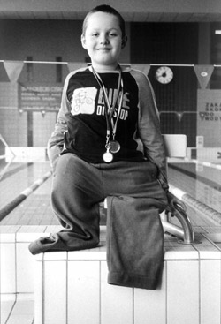 zdjęcie: niepełnosprawny chłopiec z medalami