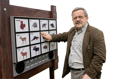 Na zdjęciu: Marek Jakuboski przy tablicy ze zwierzętami. Fot.: Damian Szymczak