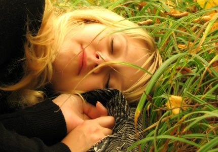 Dziewczyna śpiąca na trawie. Fot.: Maxim Kourov/www.sxc.hu
